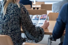 Dziewczyna z folderem informującym o ofercie edukacyjnej WZ, fot. A. Surowiec