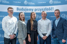 Absolwenci na tle ścianki promocyjnej WZ, fot. Arkadiusz Surowiec