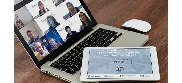 Laptop (na egranie uczestnicy seminarium podczas obrad) i tablet (na ekranie grafika informująca o seminarium)