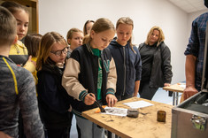 Grupa osób w laboratorium kryminalistycznym. 