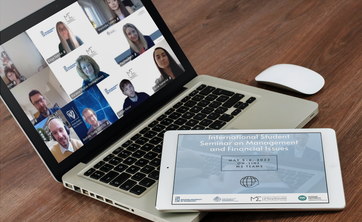 Laptop (na egranie uczestnicy seminarium podczas obrad) i tablet (na ekranie grafika informująca o seminarium)