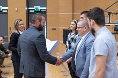 Studenci odbierający zaświadczenia o ukończeniu szkolenia teoretycznego programu "Legia Akademicka" od Pawła Wiśniewskiego, fot. Arkadiusz Surowiec