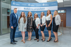 Absolwentki z dr. hab. Jackiem Strojnym, prof. PRz na tle ścianki promocyjnej WZ, fot. Arkadiusz Surowiec